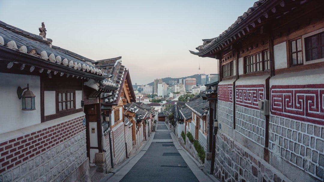 Callejón tradicional de Bukchon Hanok Village con el horizonte de Seúl de fondo